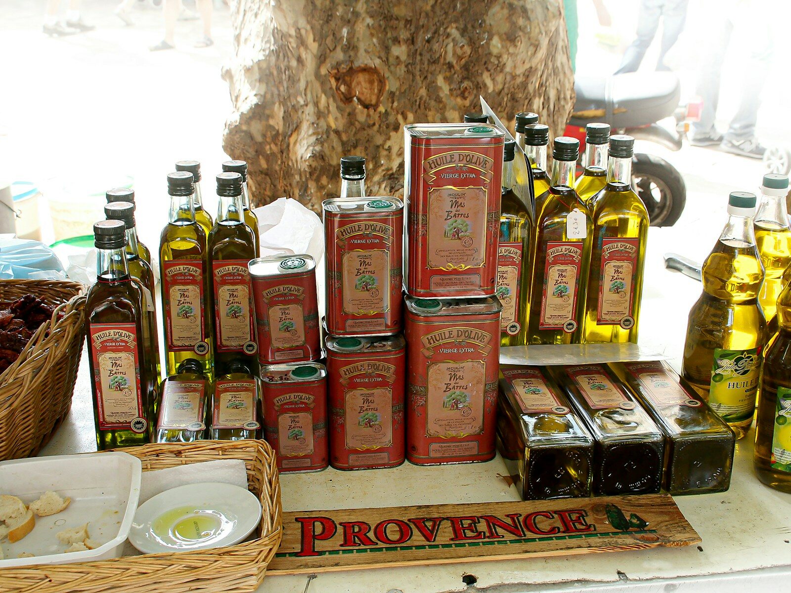 Bottles and cans of olive oil displayed at a market.
